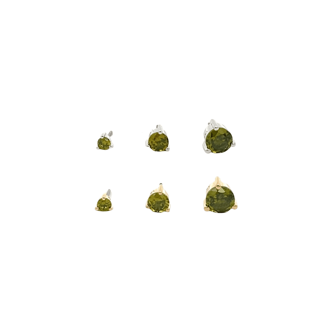 Set of six green gemstones in gold prongs on a black background