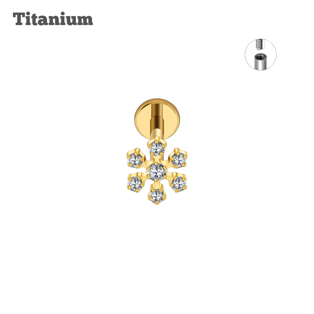 Gold snowflake-shaped earring with clear stones on a black background, labeled 'Titanium'.