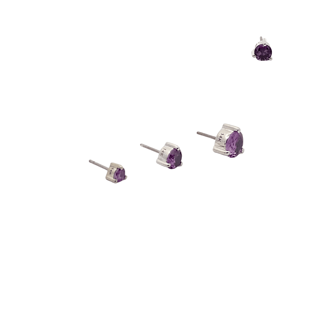 Set of purple gemstone stud earrings on a black background