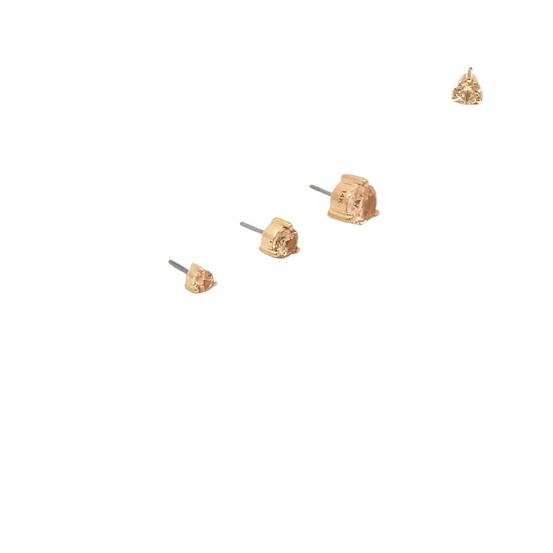 Gold stud earrings on a black background