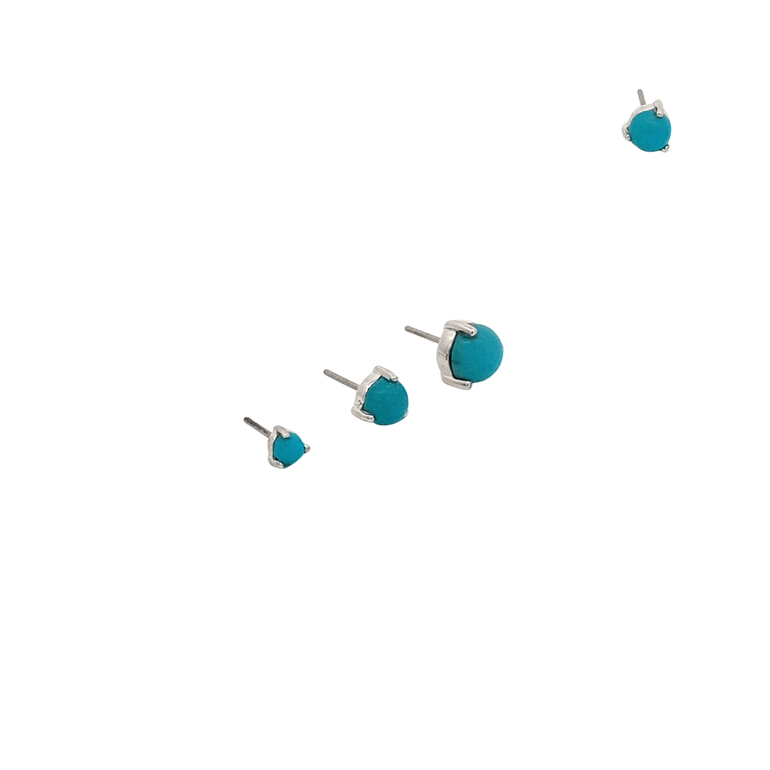 Turquoise stud earrings on a black background